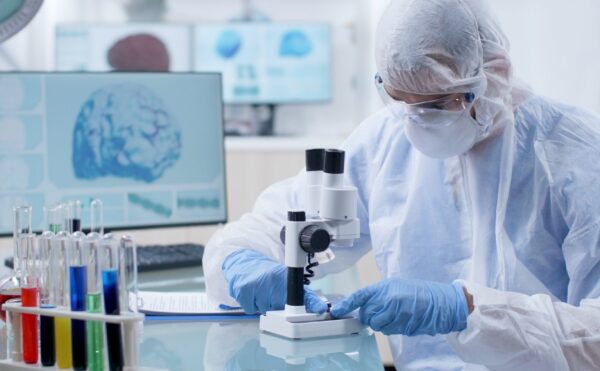 Biochemist researcher doctor adjusting medical microscope putting dna sample