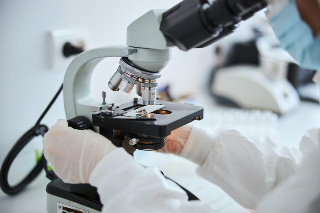 Lab technician examining cells under the microscope
