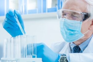 senior chemist with pipette and test tubes in laboratory