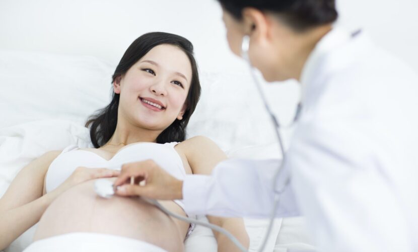 Doctor examining pregnant woman at home