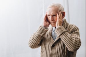 pensioner with dementia disease having headache at home